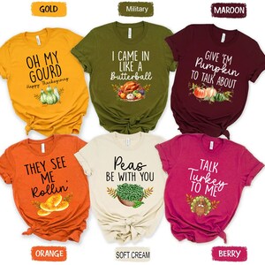 Puede incluir: Seis camisetas de diferentes colores con texto y gr&aacute;ficos de tem&aacute;tica de Acci&oacute;n de Gracias. Las camisetas son de color dorado, verde militar, granate, naranja, crema y baya.
