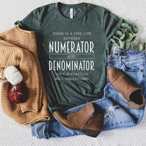 May include: A green t-shirt with white text that reads "There is a fine line between numerator and denominator. Only a fraction will understand."