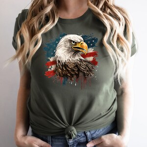 May include: A green t-shirt with a graphic of a bald eagle with a red, white, and blue American flag in the background.