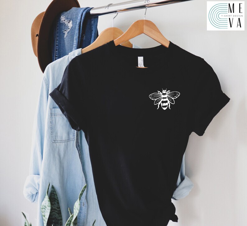 May include: Black t-shirt with a white bee graphic on the front. The bee is stylized with a simple design and has black and white stripes.