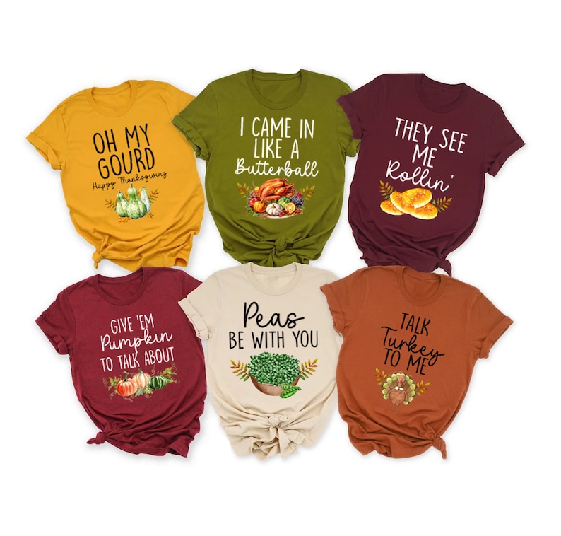Puede incluir: Seis camisetas diferentes con tem&aacute;tica de Acci&oacute;n de Gracias con varios dise&ntilde;os y lemas. Las camisetas son de diferentes colores, incluyendo granate, amarillo mostaza, verde oliva, beige y naranja. Las camisetas presentan lemas como "Oh My Gourd", "I Came In Like A Butterball", "They See Me Rollin", "Give 'Em Pumpkin To Talk About", "Peas Be With You", y "Talk Turkey To Me".