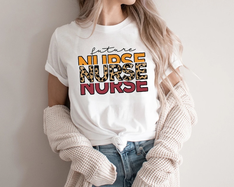 May include: White t-shirt with the text "future nurse" in a leopard print design with orange, yellow, and red accents.