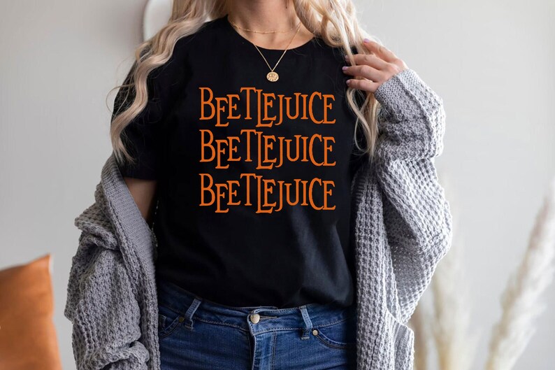 May include: A black t-shirt with the words "Beetlejuice" repeated three times in orange text.