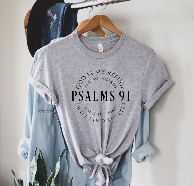 May include: Gray t-shirt with a black circle graphic that says "God is my refuge and my fortress, Psalms 91, I will find shelter under his wings".