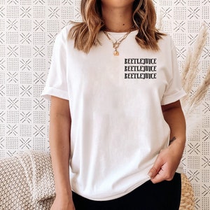 May include: White t-shirt with the text "Beetlejuice" repeated three times in black.
