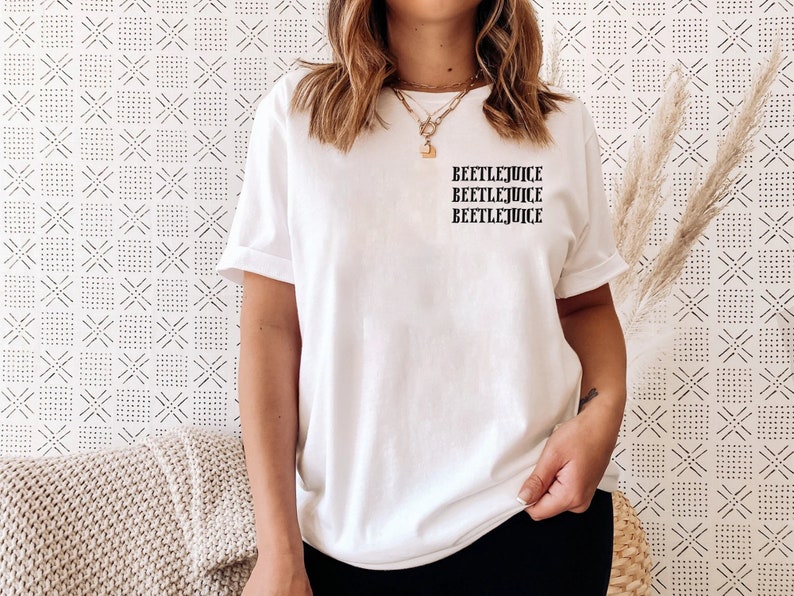 May include: White t-shirt with the text "Beetlejuice" repeated three times in black.