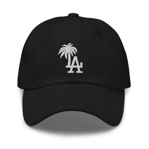 Könnte beinhalten: Schwarze Baseballkappe mit einem weißen gestickten Palmenbaum und den Buchstaben "LA" auf der Vorderseite.