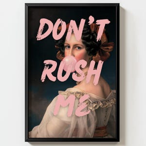 May include: Framed art print featuring a classical portrait of a woman blowing a bubblegum bubble. The words "DON'T RUSH ME" are overlaid in pink. The woman wears a white dress and a brown ribbon in her hair.