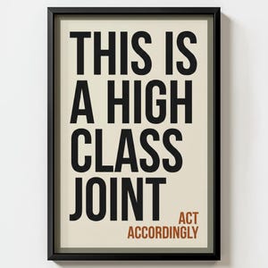 Może przedstawiać: Oprawiony wydruk artystyczny z czarną ramą. Na wydruku znajduje się tekst "THIS IS A HIGH CLASS JOINT" dużymi czarnymi literami, z "ACT ACCORDINGLY" mniejszymi brązowymi literami.
