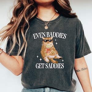 a woman wearing a t - shirt with a picture of a cat on it