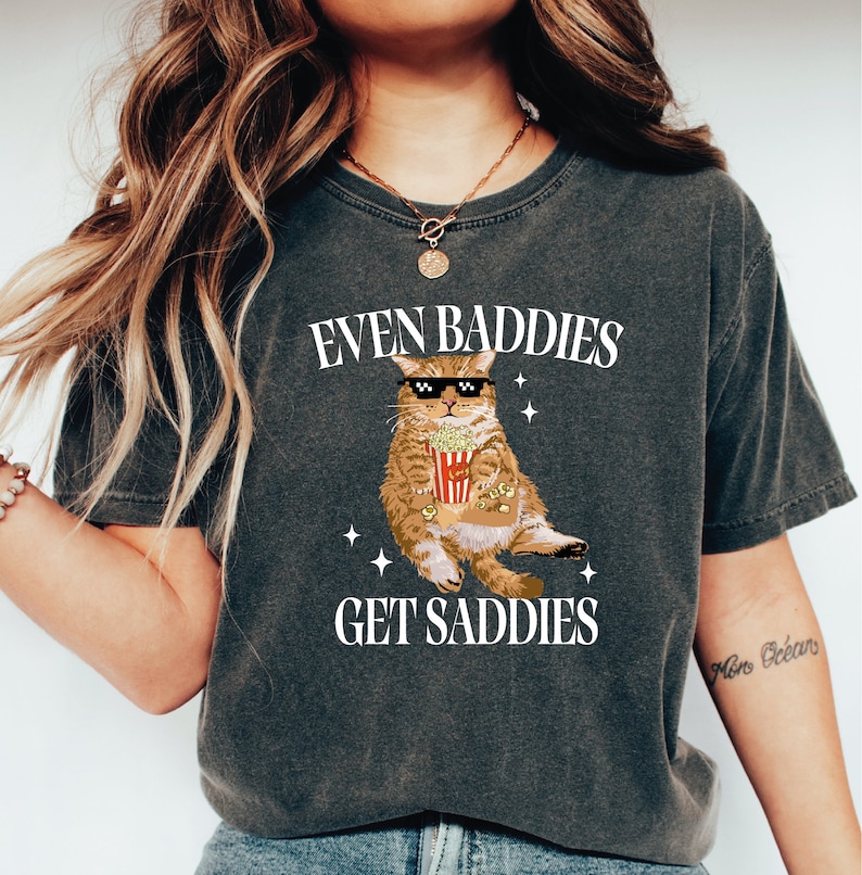 a woman wearing a t - shirt with a picture of a cat on it