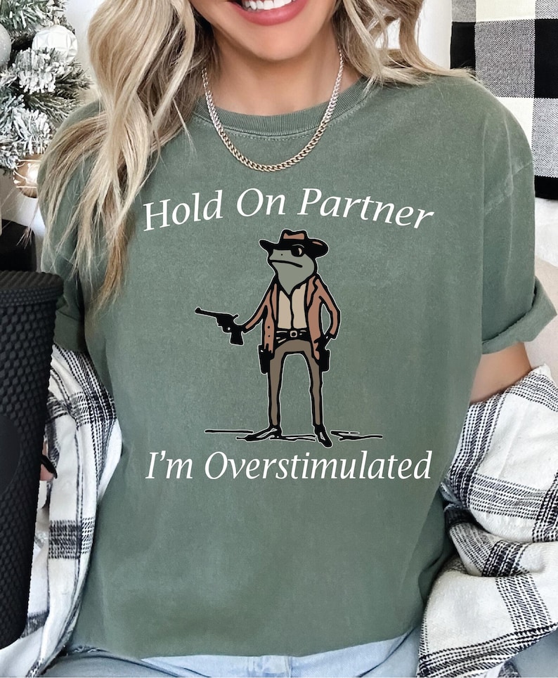 a woman wearing a t - shirt that says hold on partner i'm overs