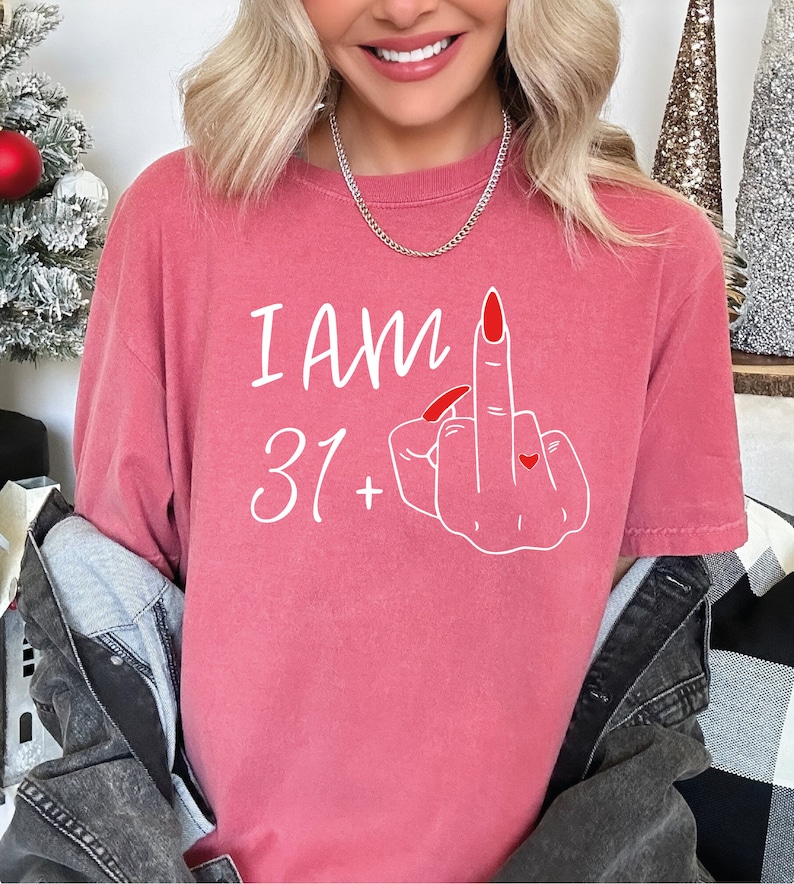 a woman with blonde hair wearing a pink shirt