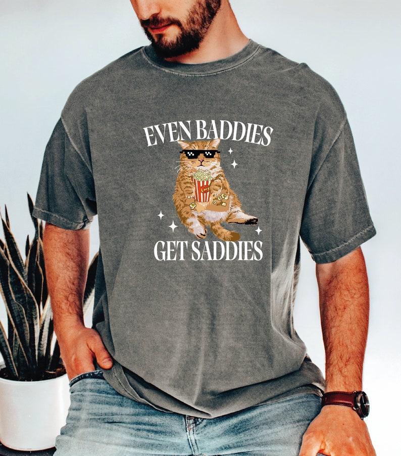 a man wearing a t - shirt that says even baddes get saddles