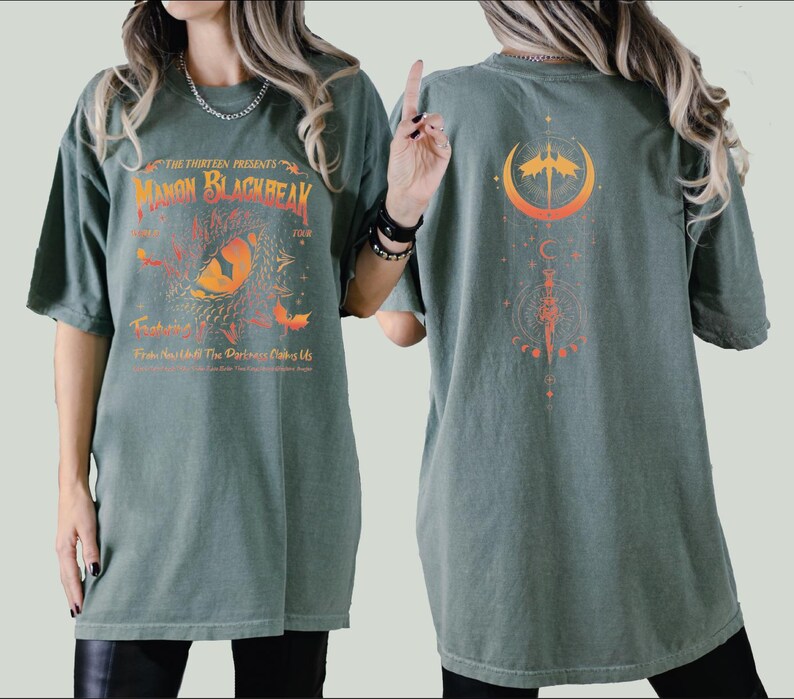 a woman wearing a green shirt with an orange design on it