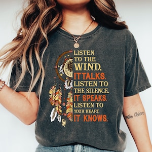 May include: A gray t-shirt with a graphic of a dreamcatcher and the text "Listen to the wind. It talks. Listen to the silence. It speaks. Listen to your heart. It knows."