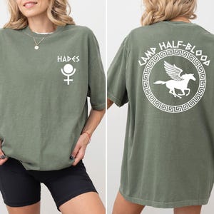 a woman wearing a green shirt with a white horse on it