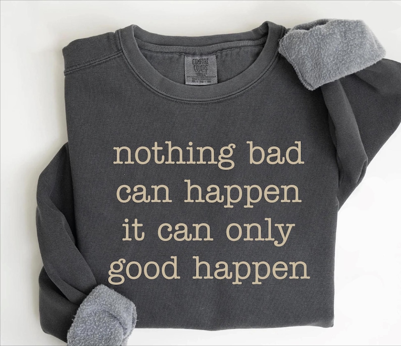 A gray sweatshirt with the text "nothing bad can happen it can only good happen" printed on it.
