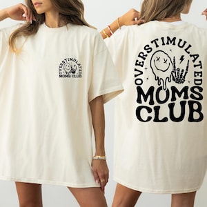 two women wearing white shirts with black letters on them