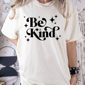 a woman wearing a t - shirt that says be kind