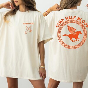two women in white t - shirts with orange logos