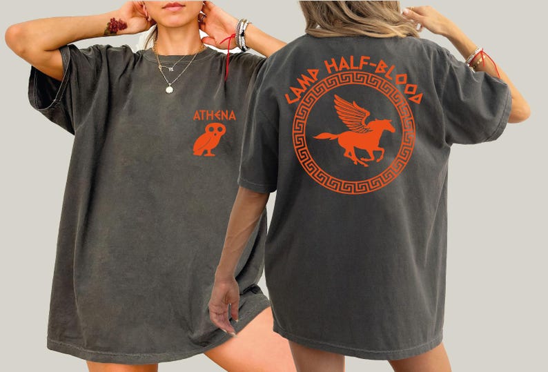 a woman wearing a gray shirt with an orange horse on it