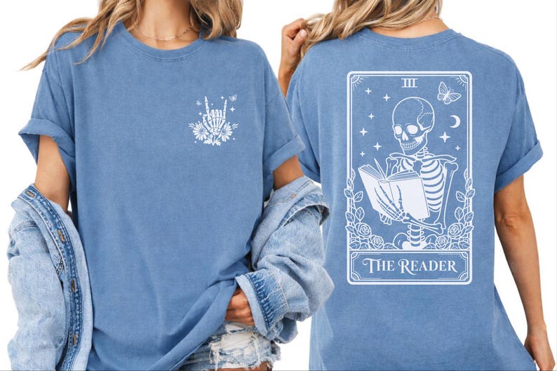 A woman wearing a blue t-shirt with a graphic design on the back, depicting a skeleton reading a book.