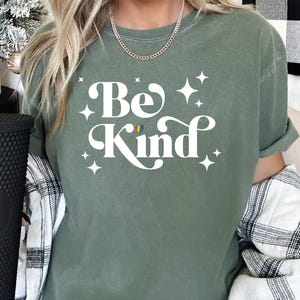 a woman wearing a be kind t - shirt
