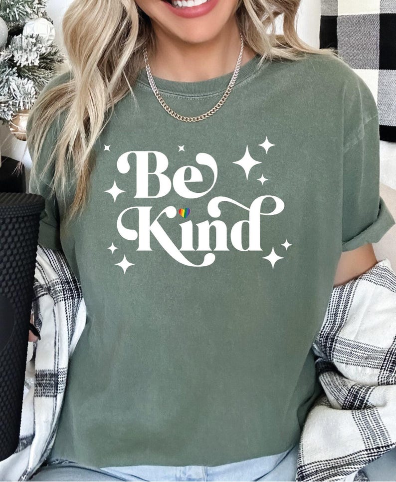 a woman wearing a be kind t - shirt