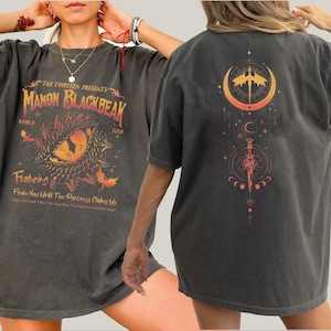 a woman wearing a black shirt with an orange design on it