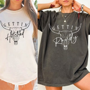 two women wearing t - shirts with a bull head on them