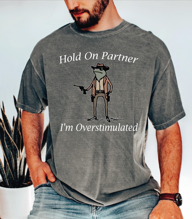 a man wearing a t - shirt that says hold on partner i'm over