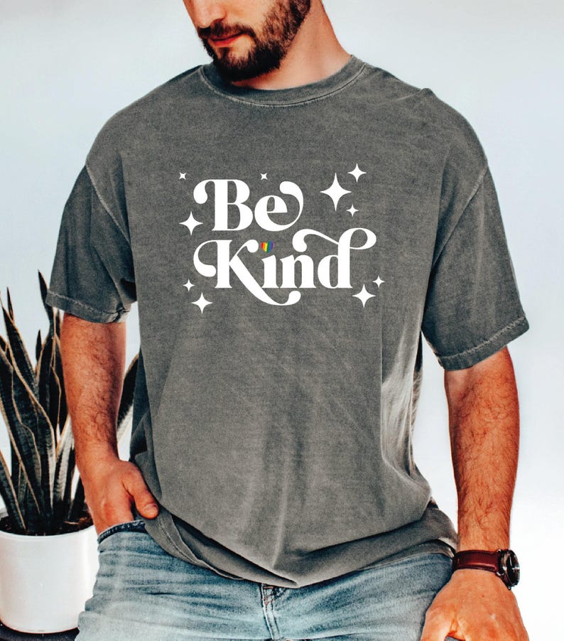 a man with a beard wearing a be kind t - shirt