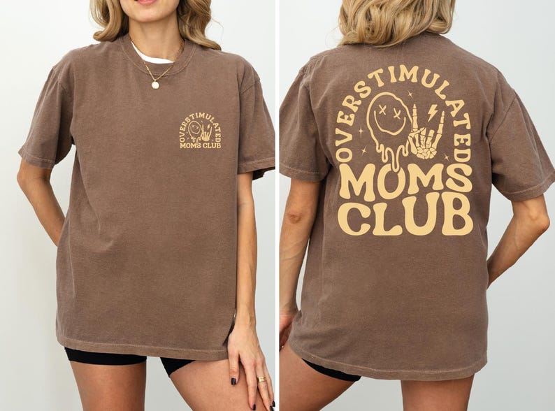 a woman wearing a brown tshirt with a mom's club on it