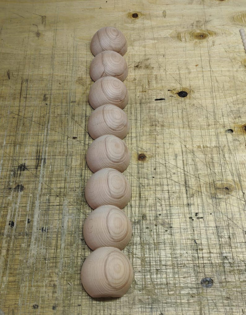 Vertical column of raw wood half-sphere beads showing natural grain
