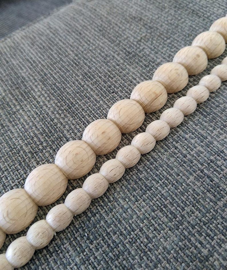 Two parallel rows of natural wood beads in different diameters