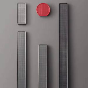 Puede incluir: Un surtido de objetos decorativos modernos y geométricos. La colección incluye piezas rectangulares y circulares con un patrón de cuadrícula en tonos grises y un acento rojo vibrante. Los objetos están colocados sobre un fondo gris neutro.