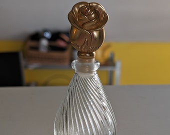 Vintage perfume bottle with golden rose on top