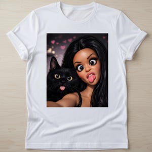 May include: White t-shirt featuring a selfie-style image of a woman and a black cat, both sticking out their tongues. The woman has long black hair and exaggerated features. The cat has yellow eyes.