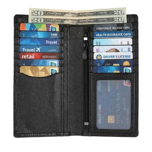 May include: Black leather wallet, open to reveal credit cards, a driving licence, and cash. The wallet features a zipped section and multiple card slots. Cards include "Travel", "Retail", and a "Health Insurance Card".