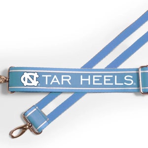 May include: A light blue and white striped adjustable strap with the text "TAR HEELS" and a white "NC" logo.