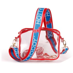 May include: Clear plastic crossbody bag with a red and blue strap that says "Ole Miss Toddy Hotty".