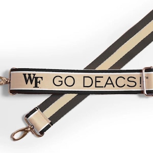 May include: A black and tan striped adjustable strap with a gold metal buckle and a white and black woven strap with the text "WF GO DEACS!" in black.
