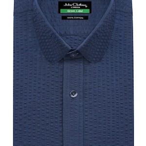 Pode incluir: Camisa azul marinho texturizada com botões na frente. A camisa tem uma gola clássica e é rotulada como "John Clothier LONDON Green Label 100% Cotton."