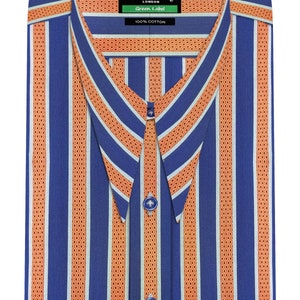 Puede incluir: Una camisa de vestir a rayas azules y naranjas con cuello puntiagudo y cierre de botones. La camisa tiene una etiqueta que dice "John Clothier, London Green Label 100% Algodón".