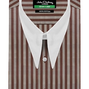 Puede incluir: Una camisa de manga larga con botones, un patrón de rayas verticales en marrón y bronceado y un cuello puntiagudo blanco en contraste. La etiqueta interior dice John Clothier London Green Label 100% Cotton. La camisa tiene una tapeta de botones.