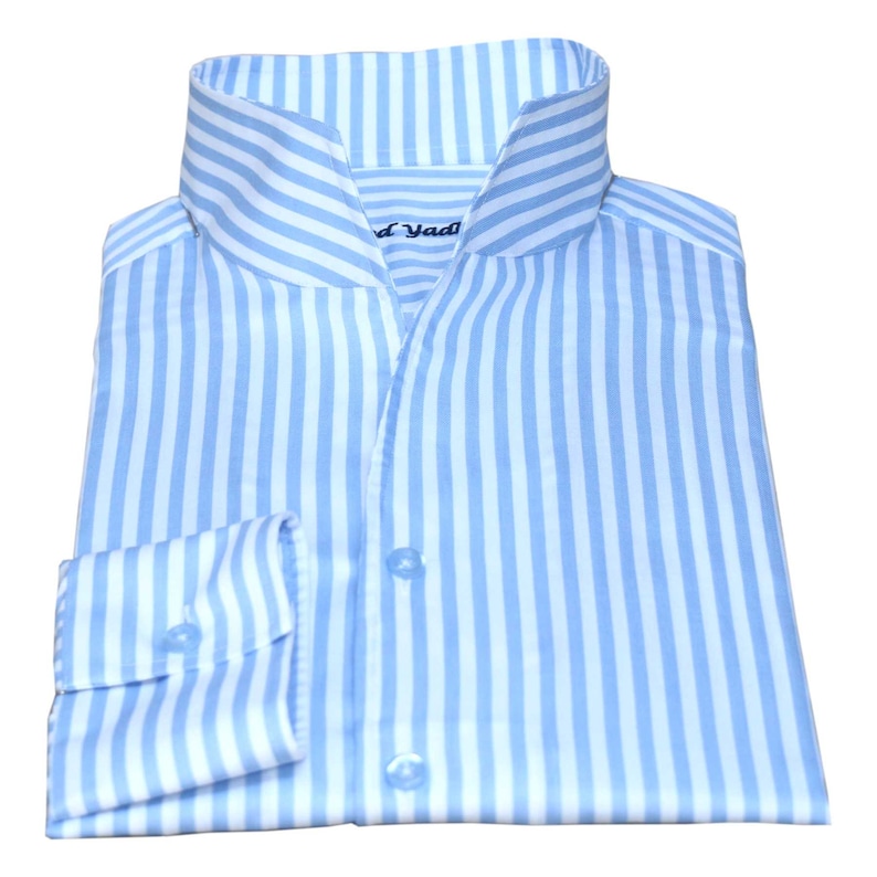 May include: A light blue dress shirt with white vertical stripes. The shirt has a mandarin collar and a button-up front. The brand name "Jad" is visible on the collar.