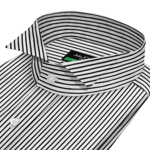 Puede incluir: Primer plano de una camisa blanca con rayas negras. La camisa tiene un cuello clásico y puños abotonados. La etiqueta dice "John Charles". La camisa está hecha de una tela crujiente y ligera.