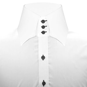 May include: A white dress shirt with a button-down collar and black buttons. The collar has a pointed, wingtip design.