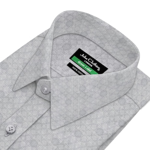 May include: A white dress shirt with a small, repeating pattern. The shirt has a button-down collar and a label that reads "John Clothier London Green Label 100% Cotton".